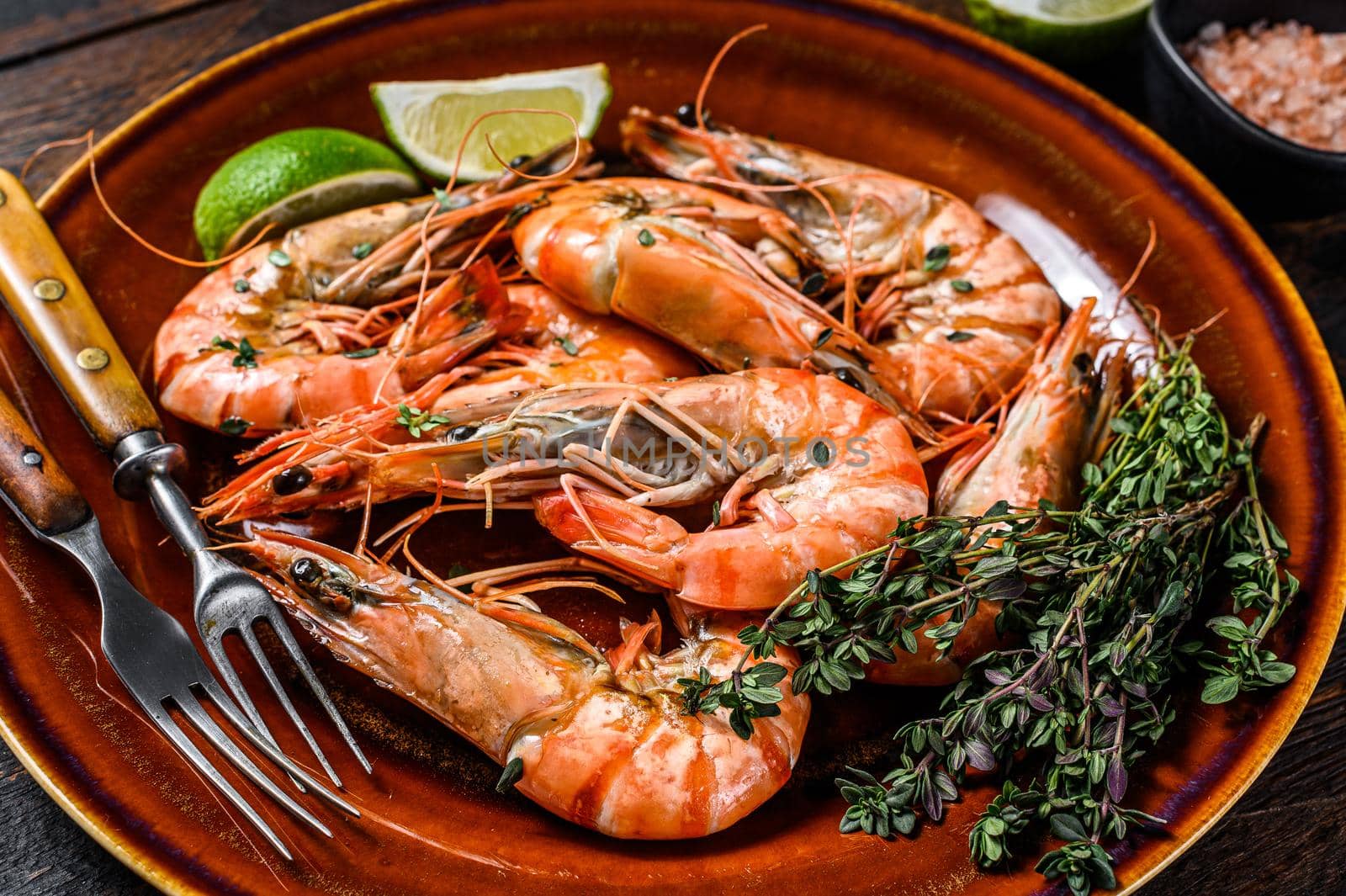 Roasted giant tiger shrimps Prawns on a plate. Dark wooden background. Top view by Composter