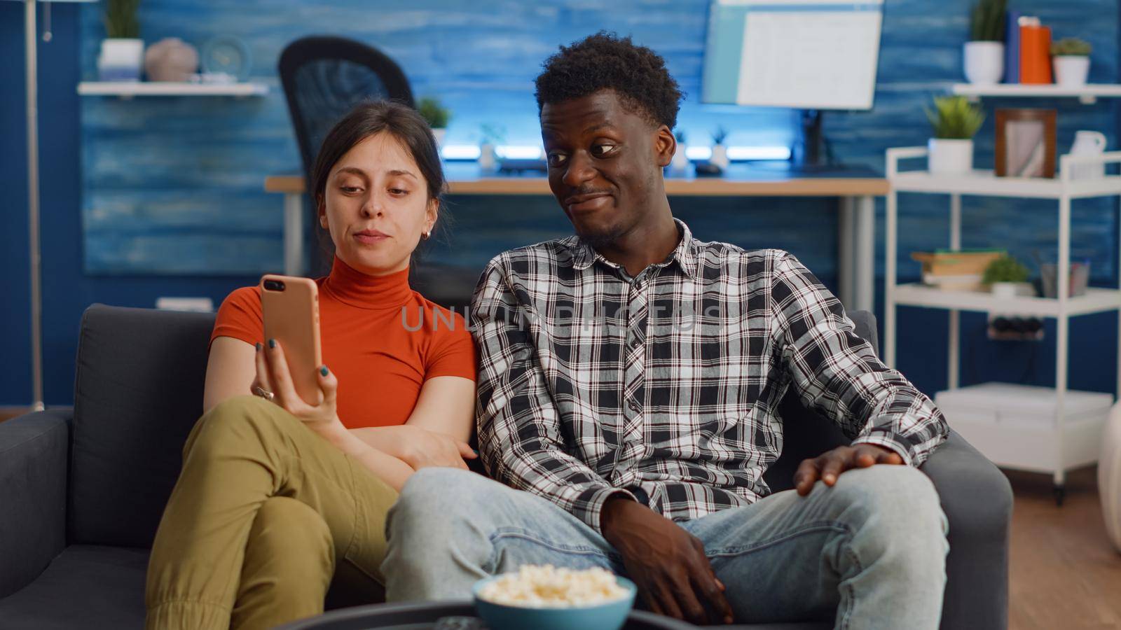 Young interracial couple talking on video call with camera by DCStudio