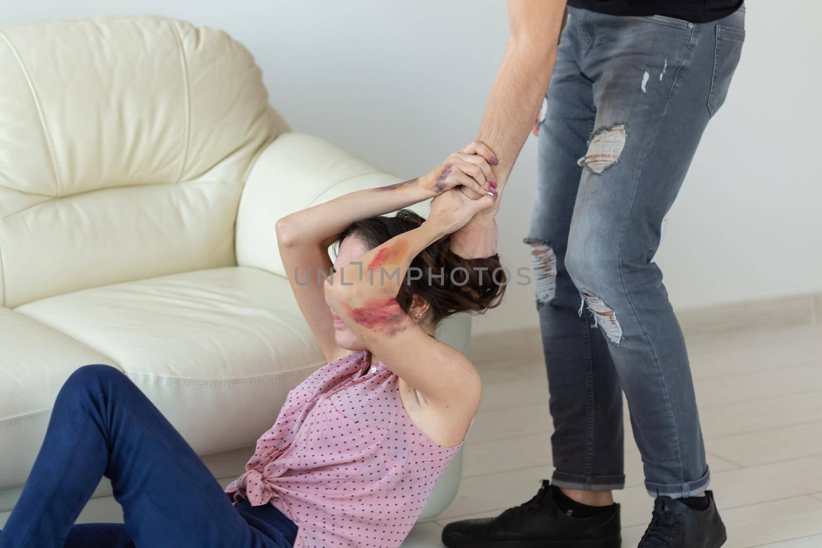 domestic violence, alcoholic and abuse concept - drunk man with bottle grabbing his wife lying on the floor.