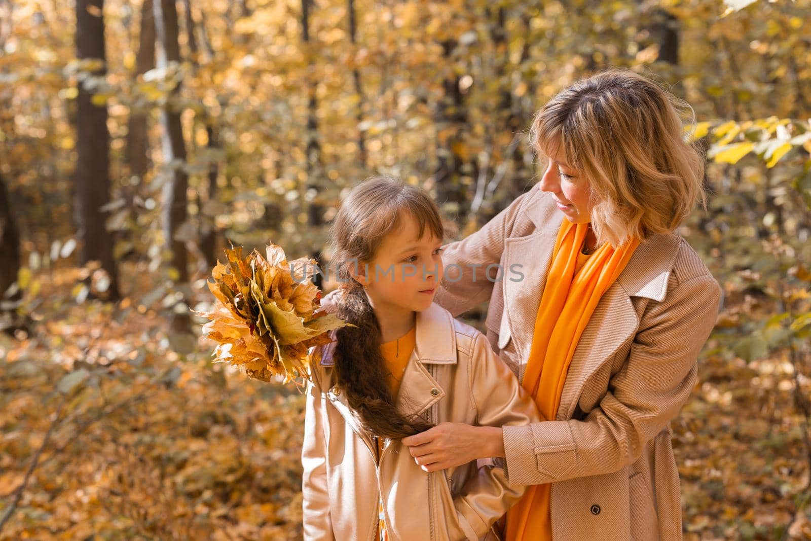 Beautiful lifestyle autumn photo mother and child walks evening in the park, warm sunlight. by Satura86