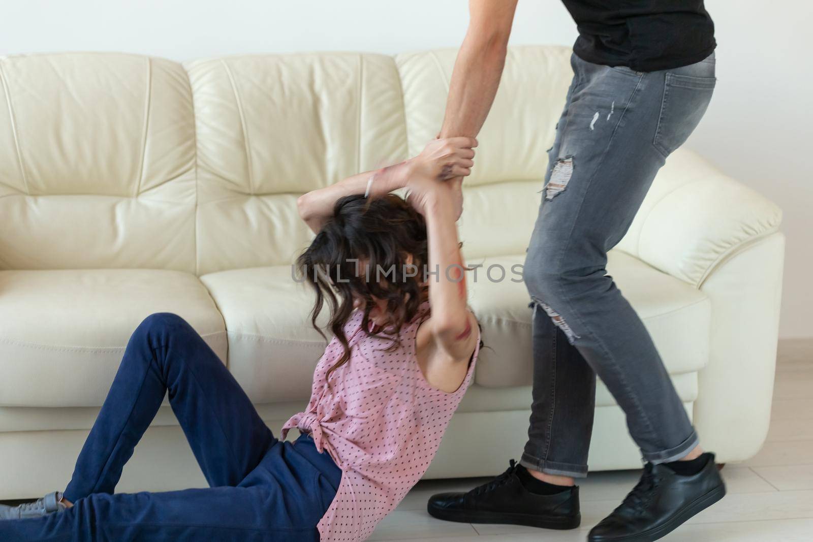 domestic violence, alcoholic and abuse concept - aggressive man grabbing his wife lying on the floor.