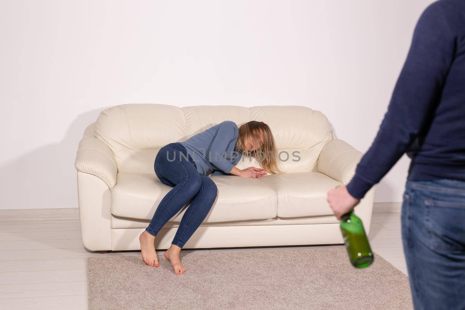 People, violence and abuse concept - Man drinking alcohol while wife is lying on sofa by Satura86