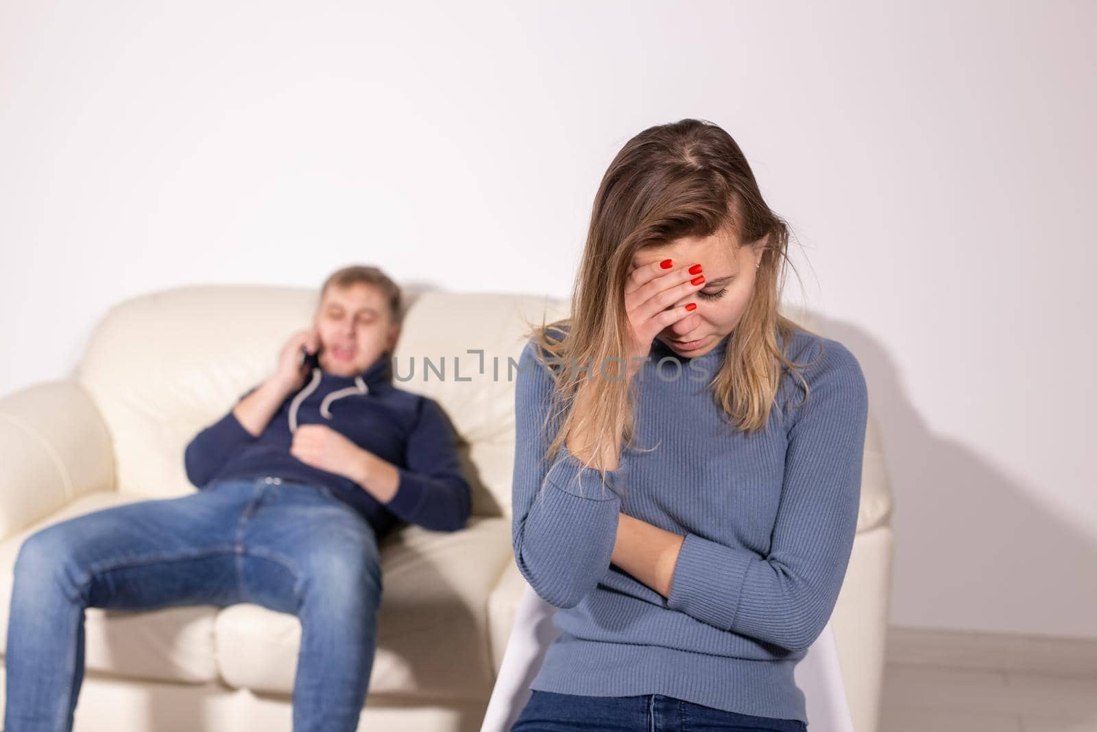 domestic violence, abuse and family concept - crying woman and her husband on the background.