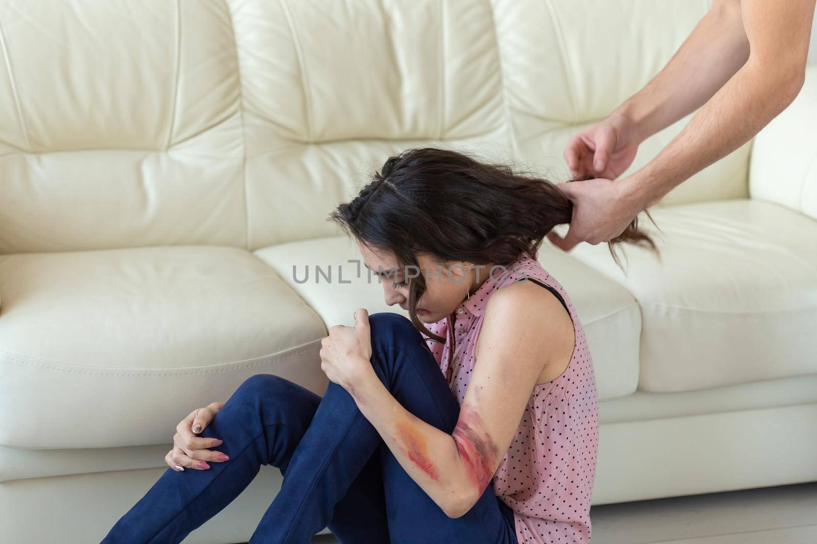 domestic violence, alcoholic and abuse concept - drunk man with bottle grabbing his wife lying on the floor.