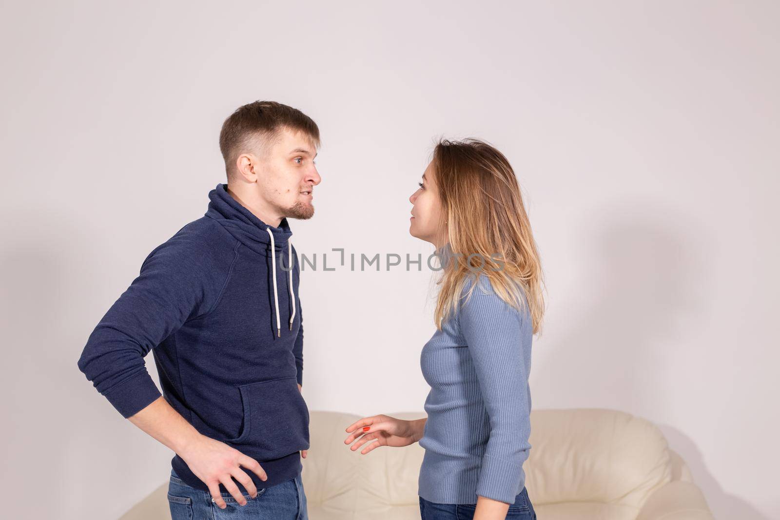 people, domestic violence and abuse concept - young couple arguing indoors by Satura86