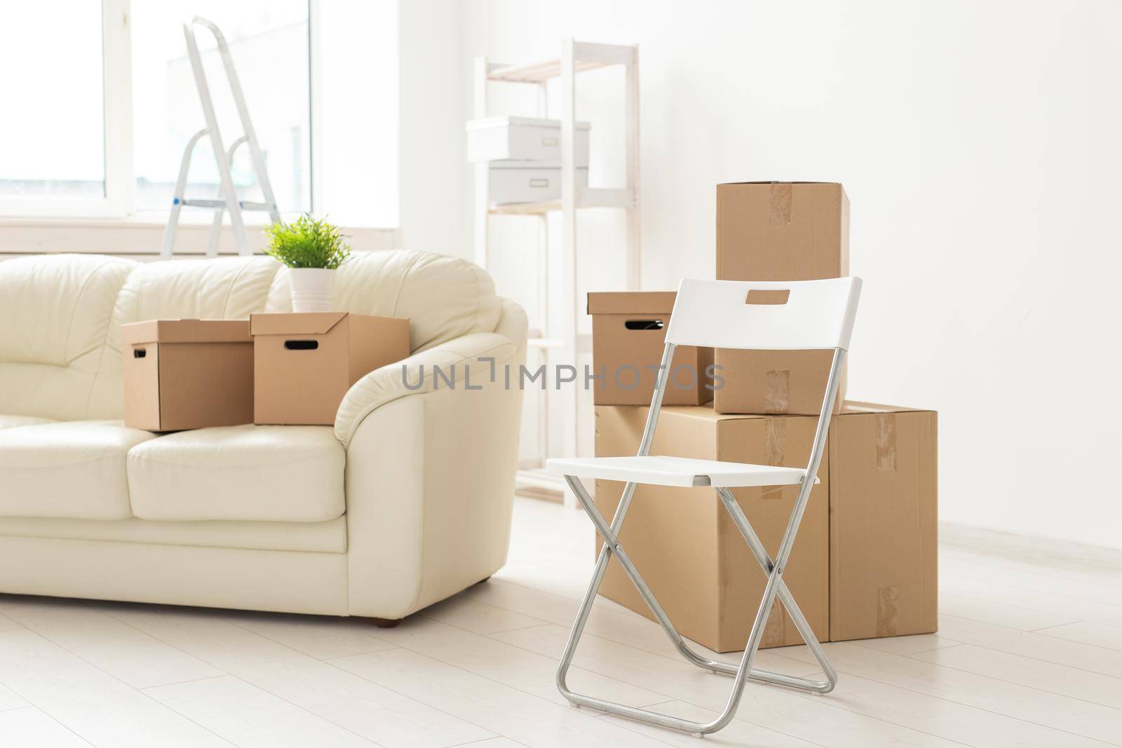 Folding chair sofa and boxes are in the new living room when residents move to a new apartment. The concept of new buildings and comfortable housing for young people