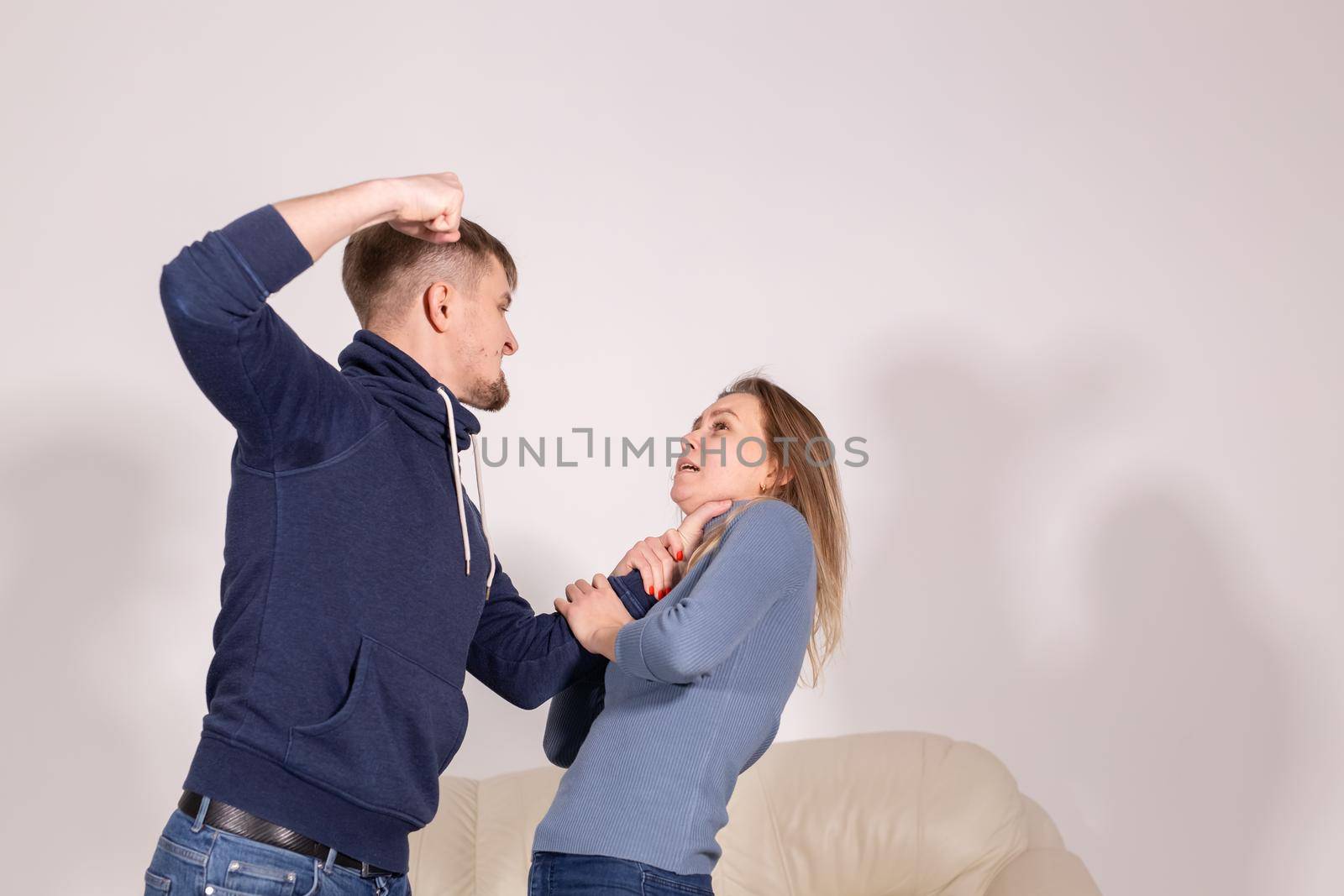 People and abuse concept - Portrait of angry young man try to hit the woman by Satura86