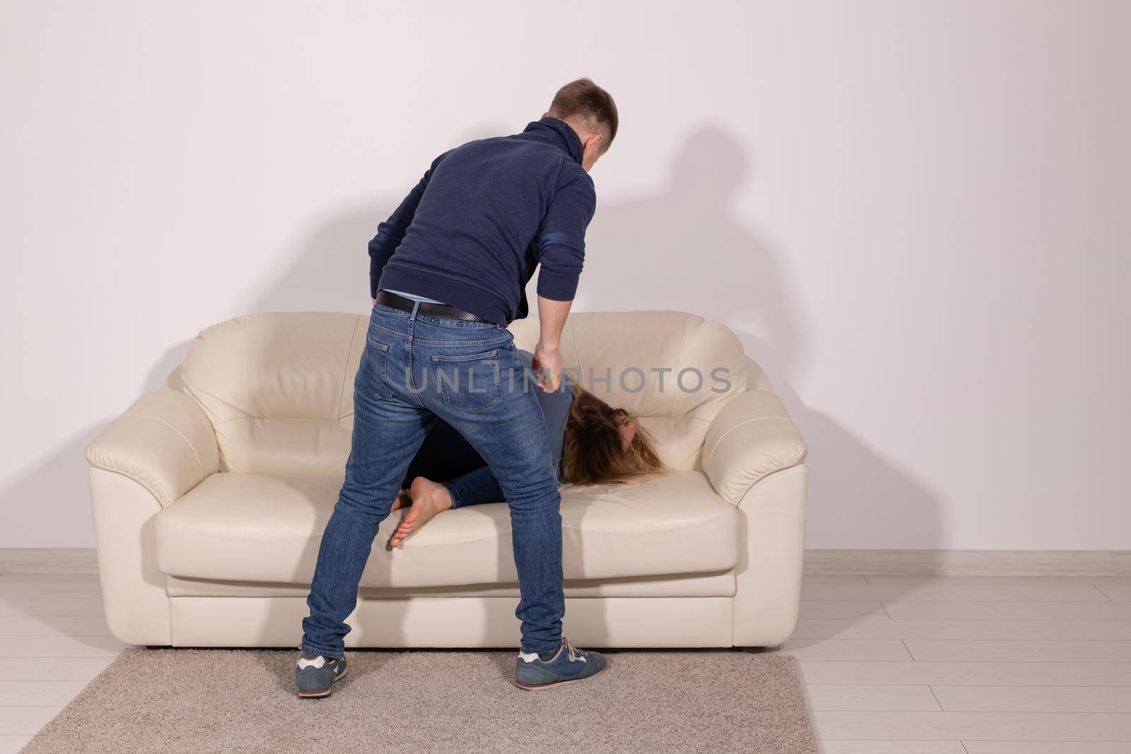 people, abuse and violence concept - aggressive man hitting his wife on sofa.