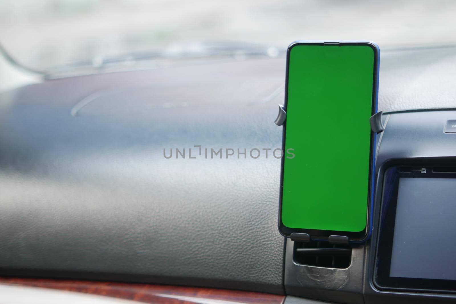 smart phone with green screen on car dashboard .