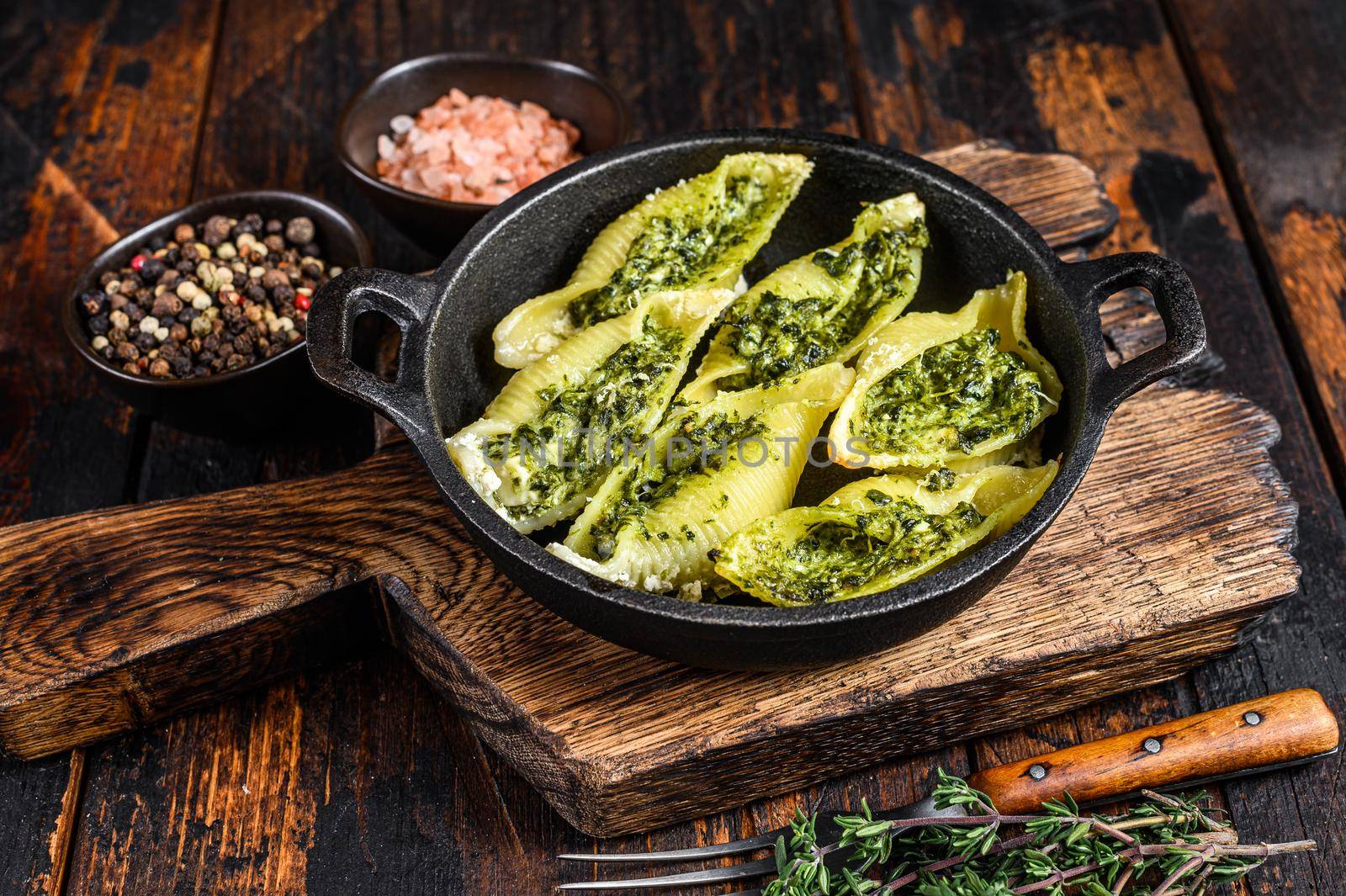 Jumbo shells italian pasta Conchiglioni konkiloni stuffed with beef meat and spinach. Dark Wooden background. Top view by Composter