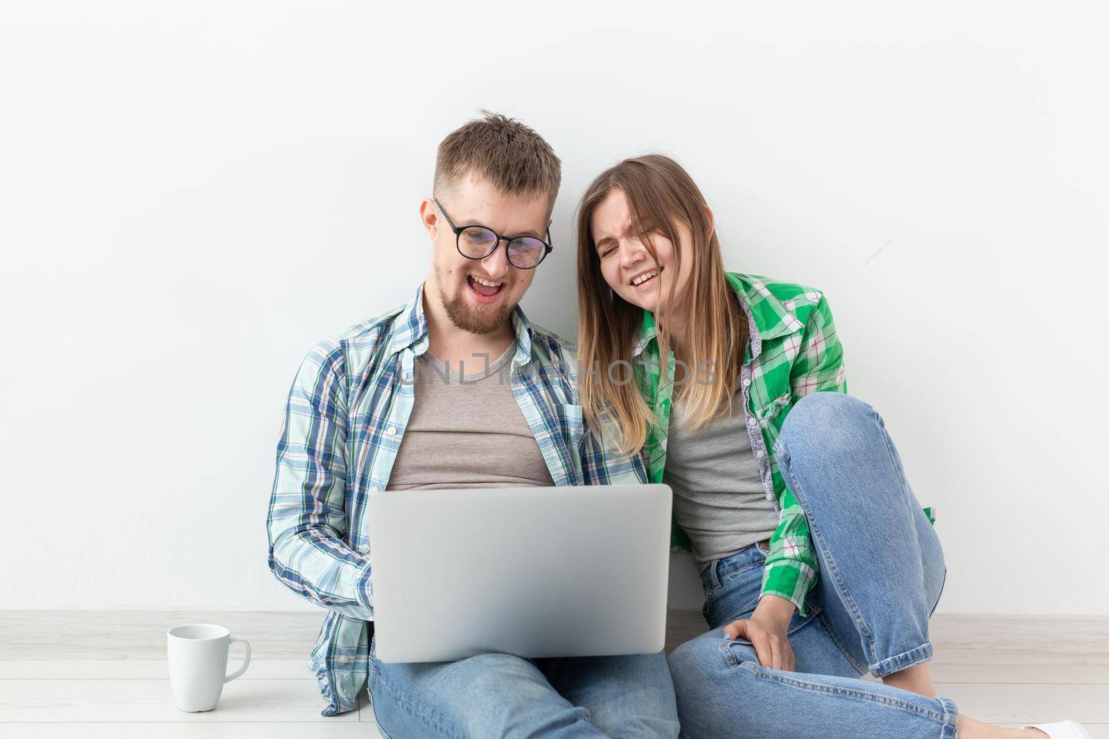 Charming young woman and a smiling man are watching online stores using a laptop to buy plumbing in a new apartment. Housewarming and repair concept. Copyspace