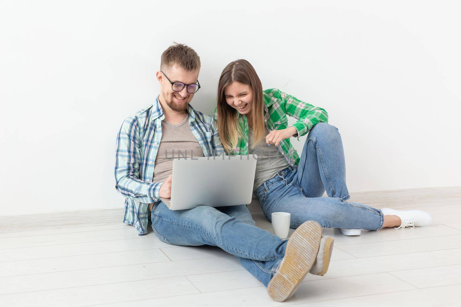 Charming young woman and a smiling man are watching online stores using a laptop to buy plumbing in a new apartment. Housewarming and repair concept. by Satura86