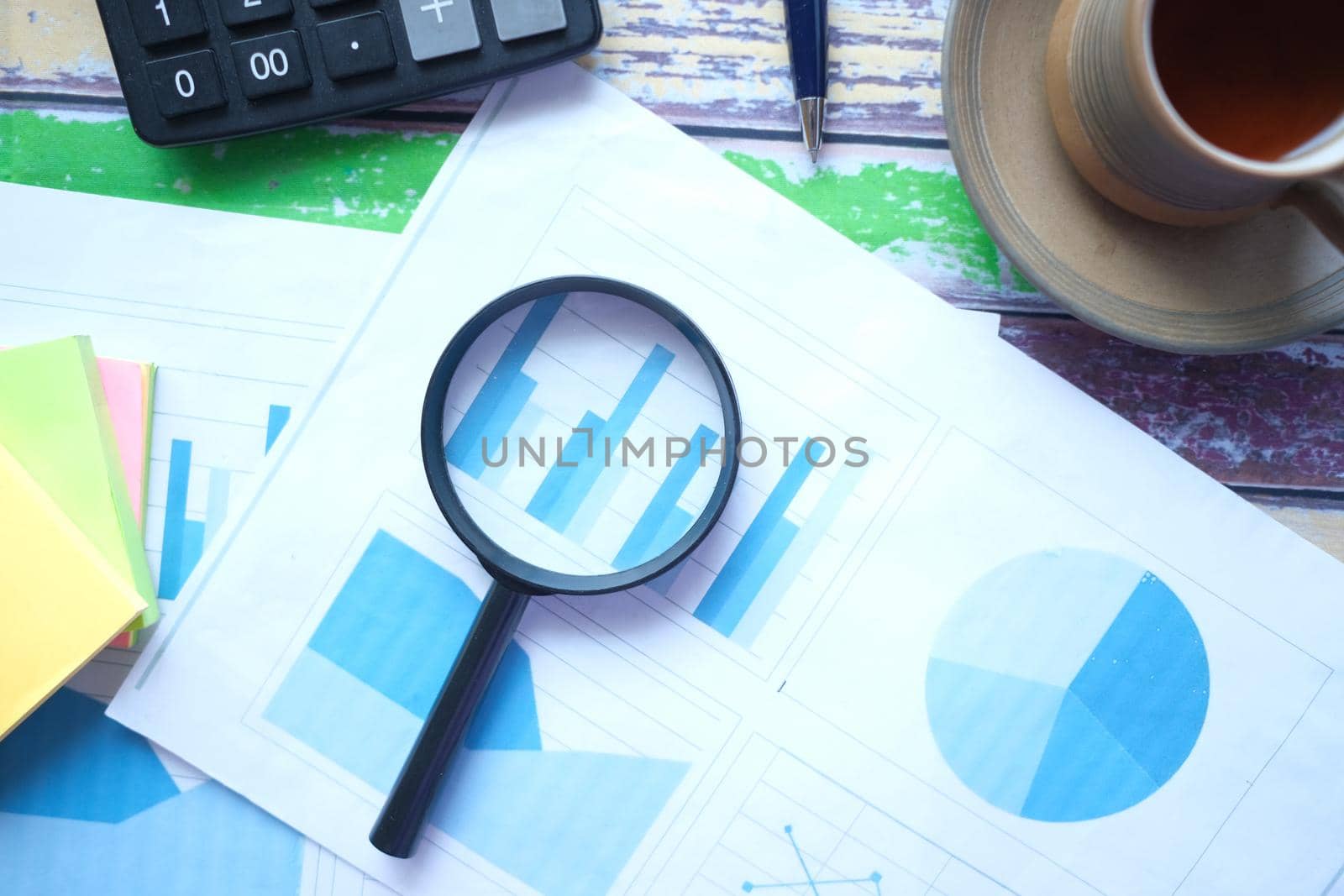 financial data and magnifying glass on blue