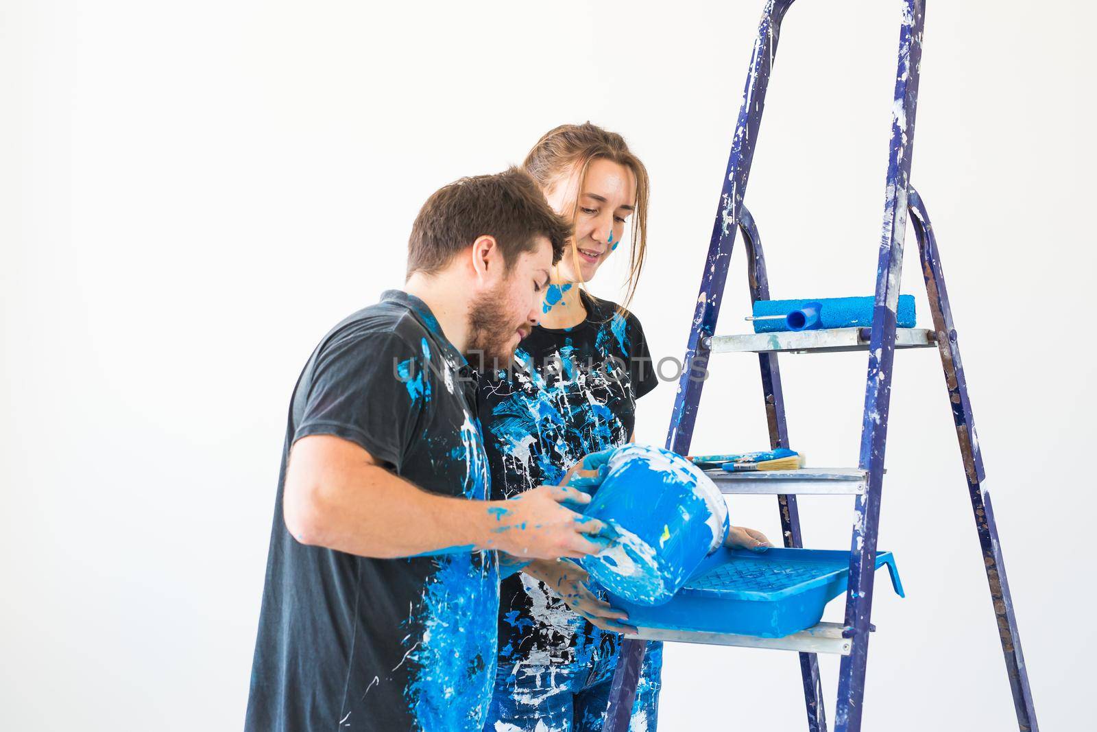 Repair, color, people concept - couple going to paint the wall, they are preparing the color.