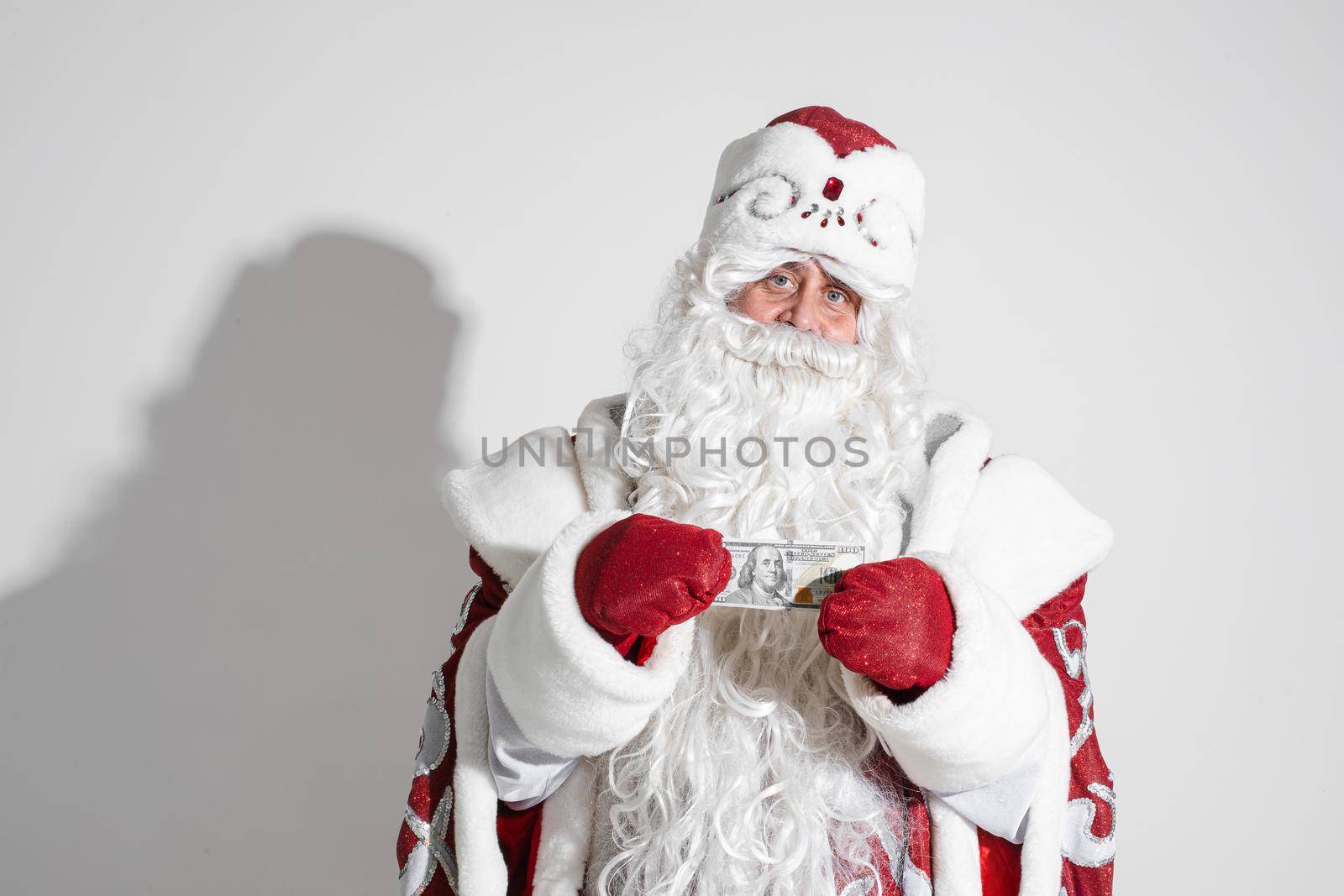 santa claus with long white beard shows money, picture isolated on white background