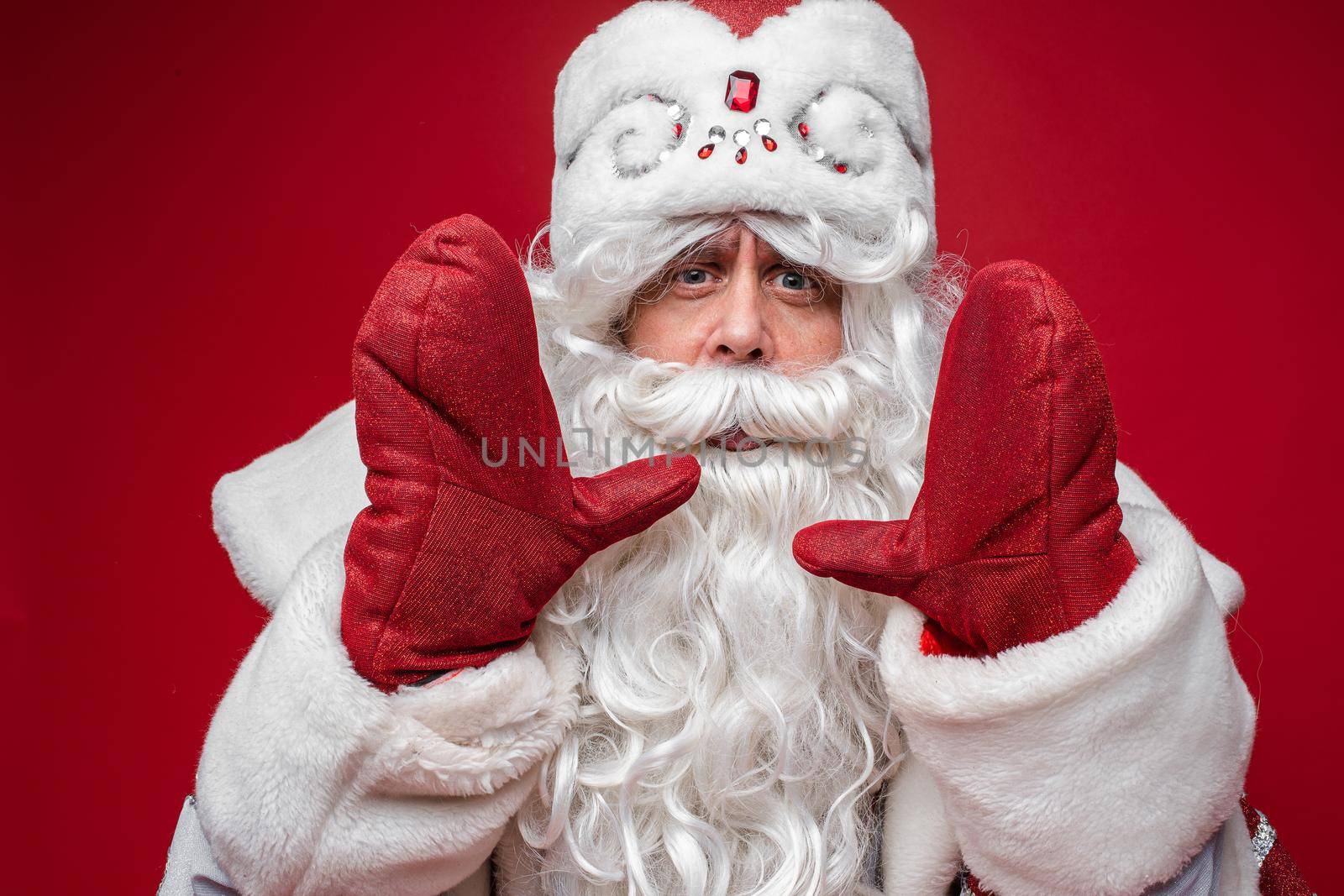 portrait of father frost in long warm coat, red gloves and a hat calling someone by StudioLucky