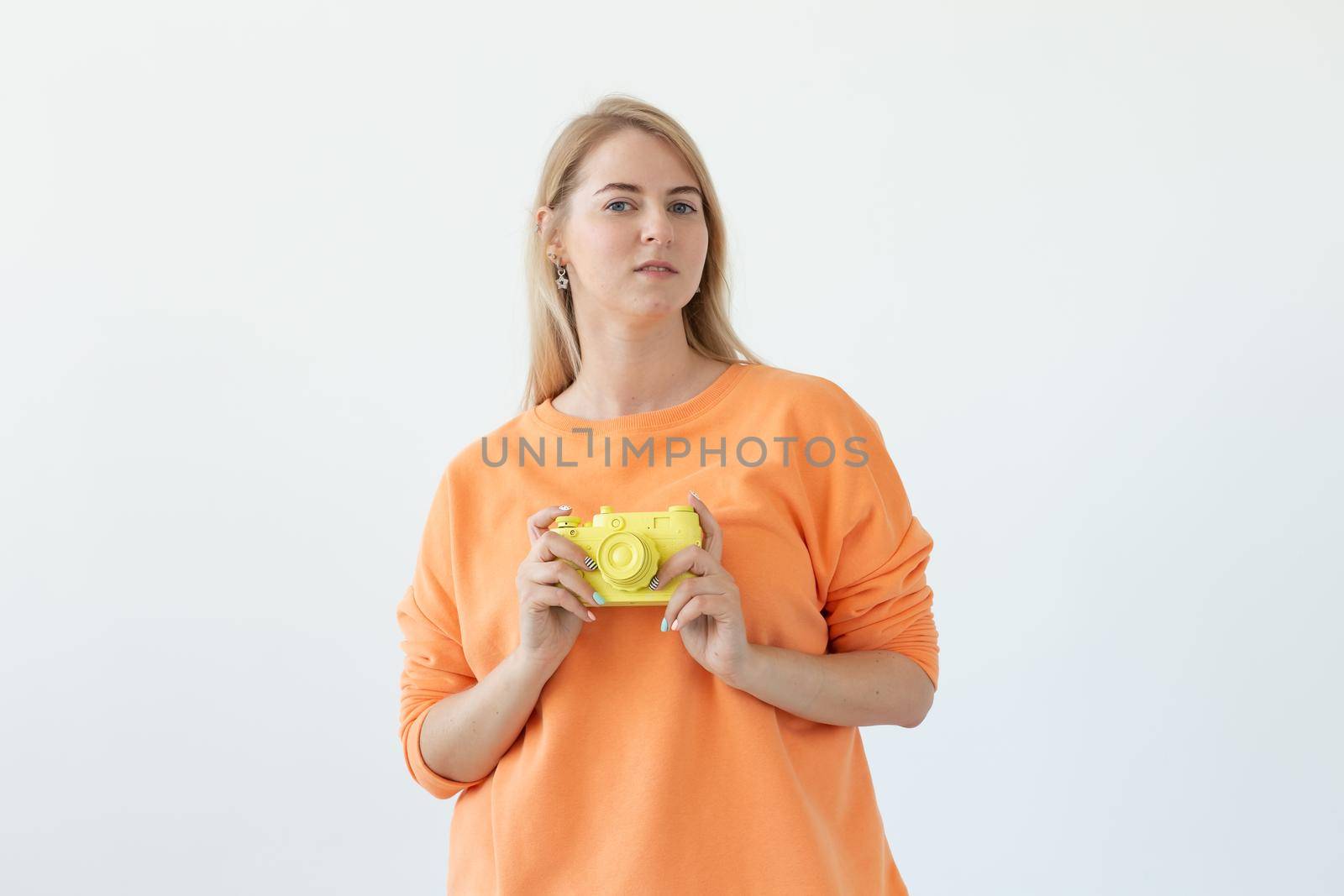 Photographer, hobby and leisure concept - Young blond woman with retro camera on white background with copy space.