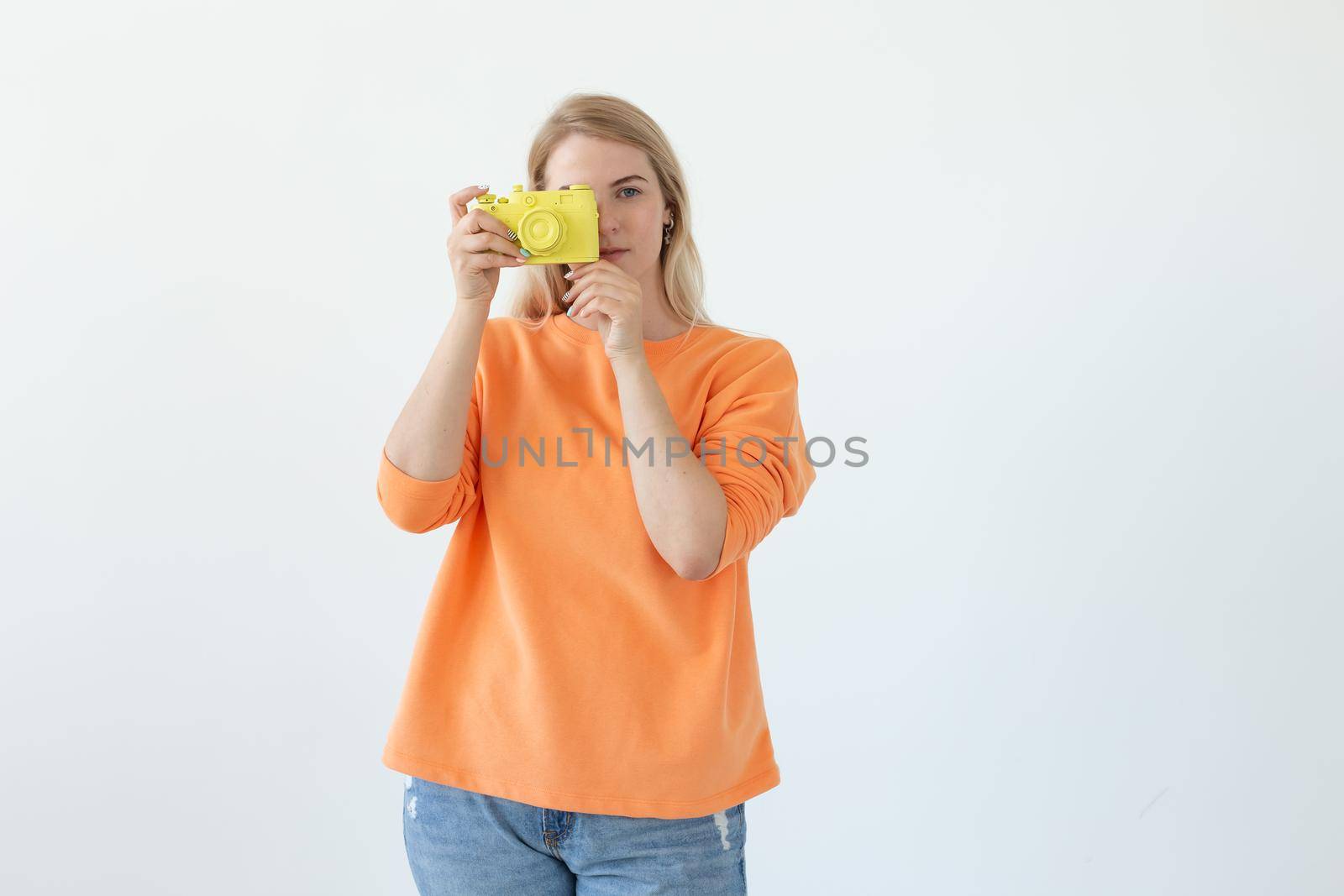 Photographer, hobby and leisure concept - Young blond woman with retro camera on white background with copy space.