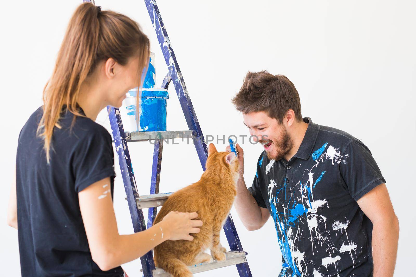 People, redecoration and renovation concept - portrait of couple with cat pour paint by Satura86