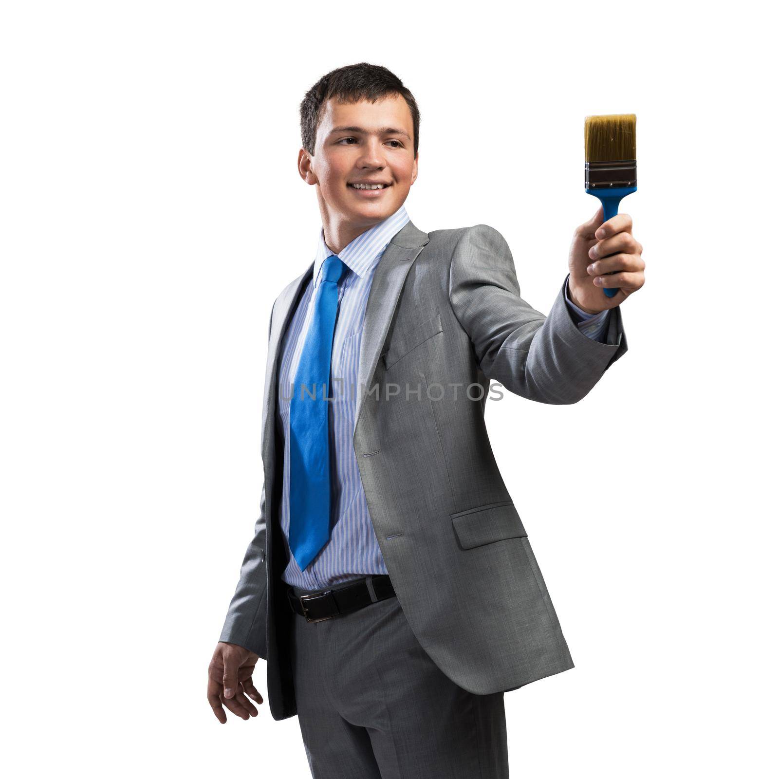 Smiling creative businessman painter holding paintbrush in hand. Portrait of joyful handsome man in business suit and tie isolated on white background. Ambitions and creativity in business concept.