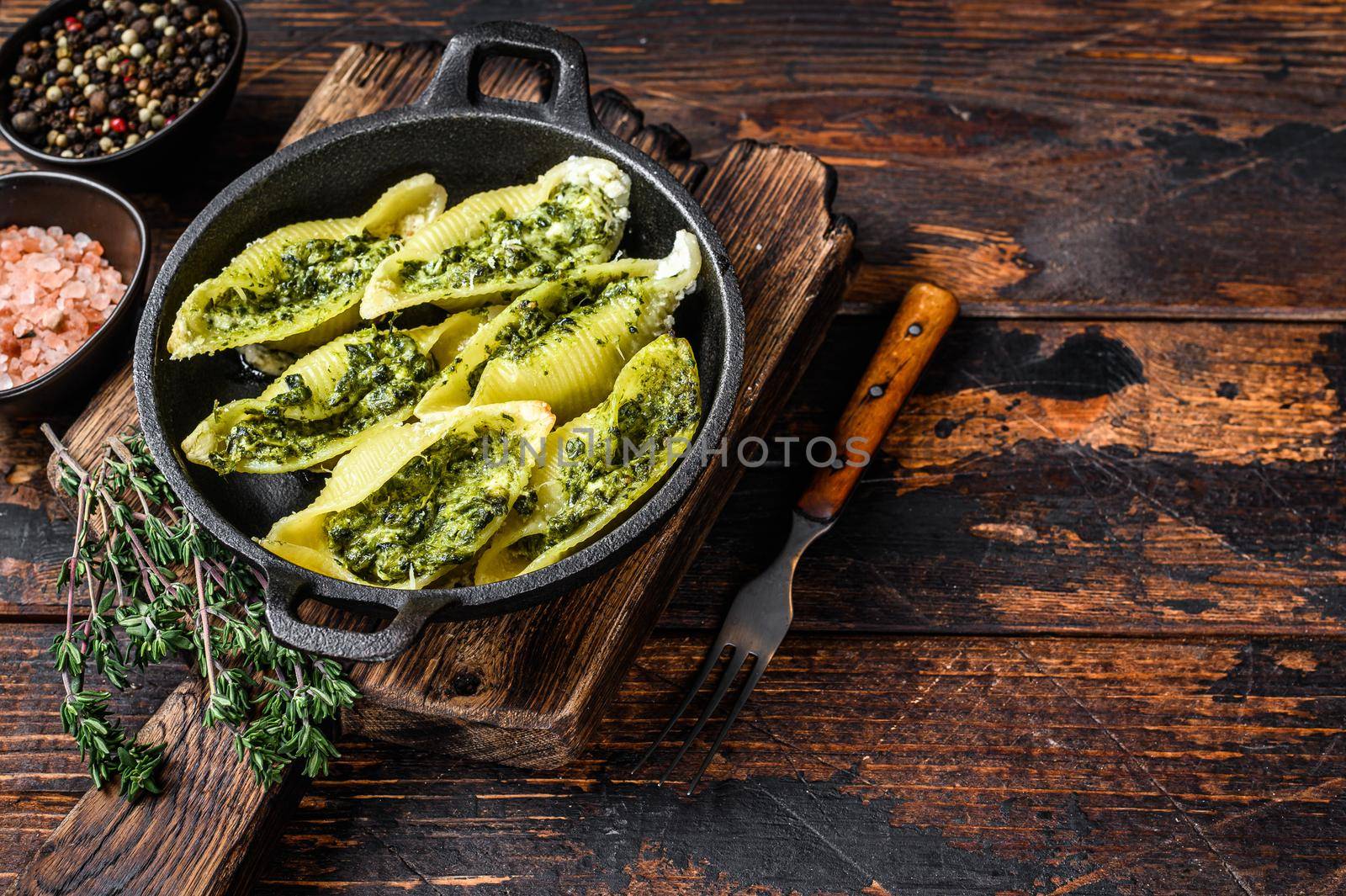 Jumbo shells italian pasta Conchiglioni konkiloni stuffed with beef meat and spinach. Wooden background. Top view. Copy space.