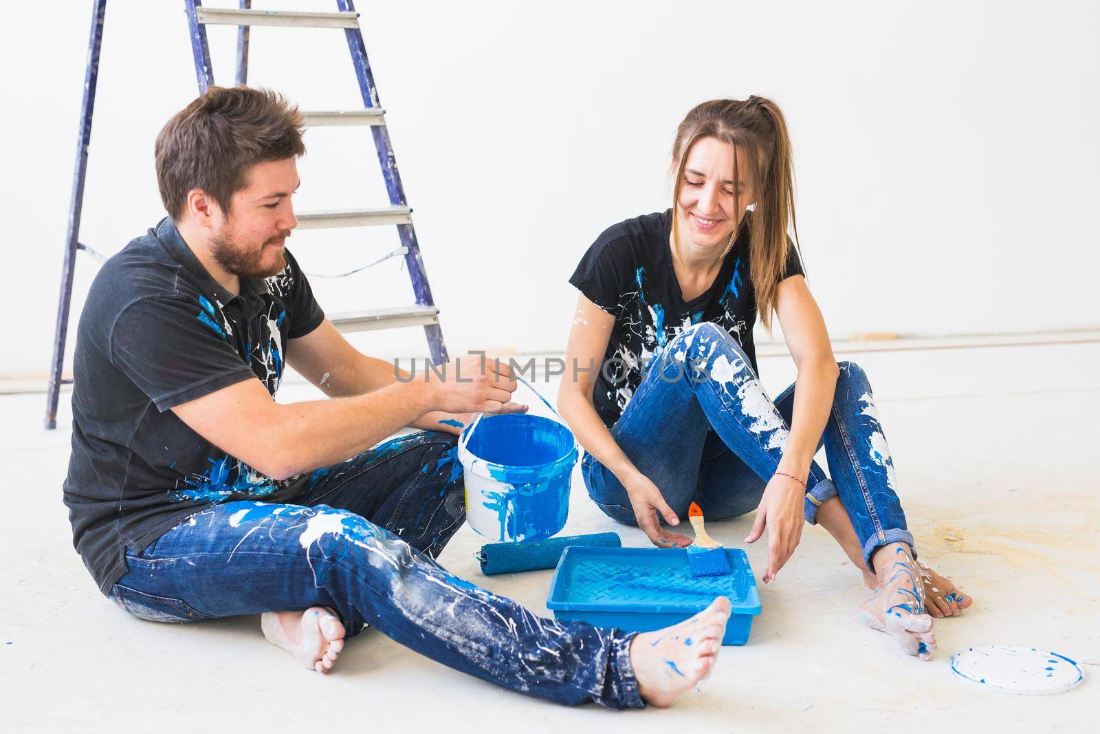 Repair, renovation and people concept - Close up portrait of couple pour paint.