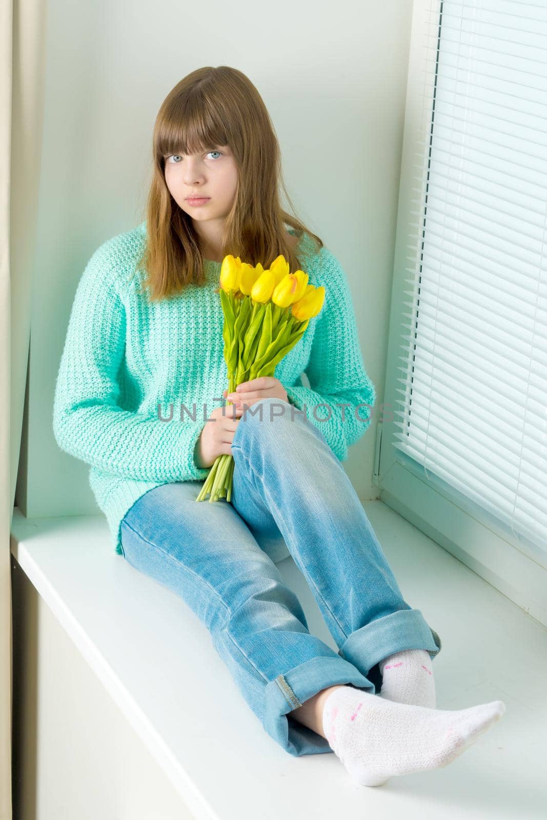 A little girl is sitting on the windowsill with a bouquet of tul by kolesnikov_studio
