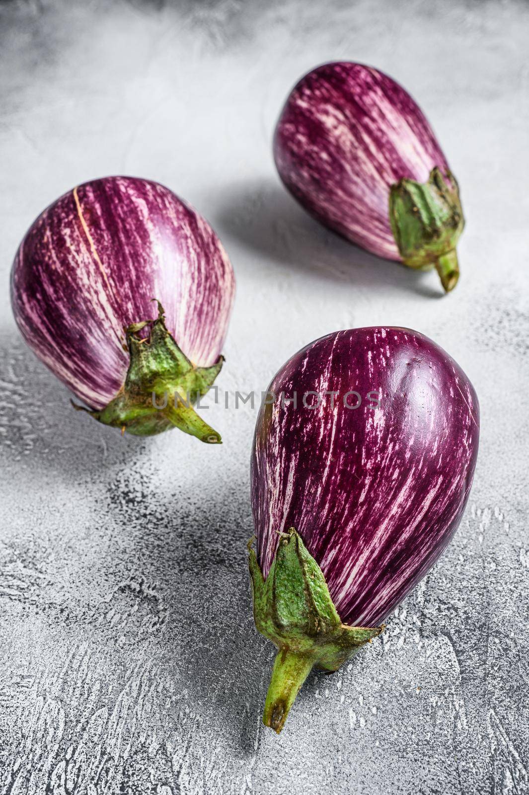 Raw small purple Asian eggplants. White background. Top view.