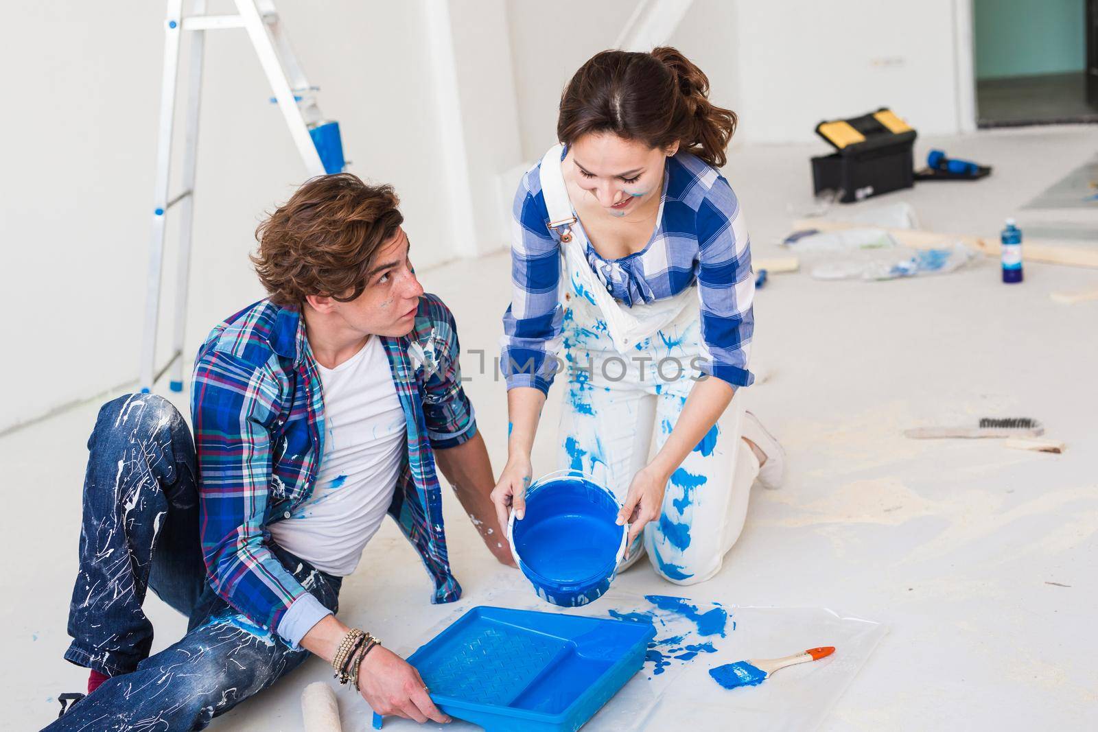 Repair, renovation and people concept - Close up portrait of couple pour paint.