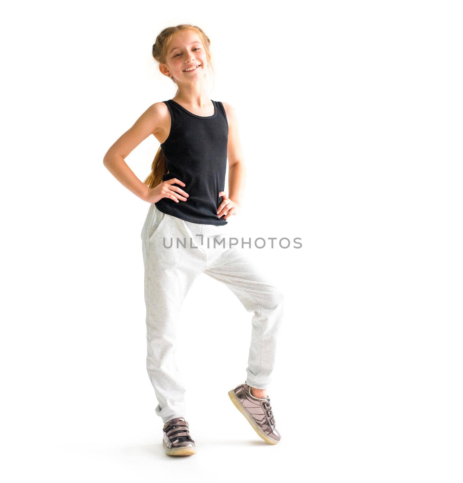 Happy little girl smiling standing in front of camera on white background
