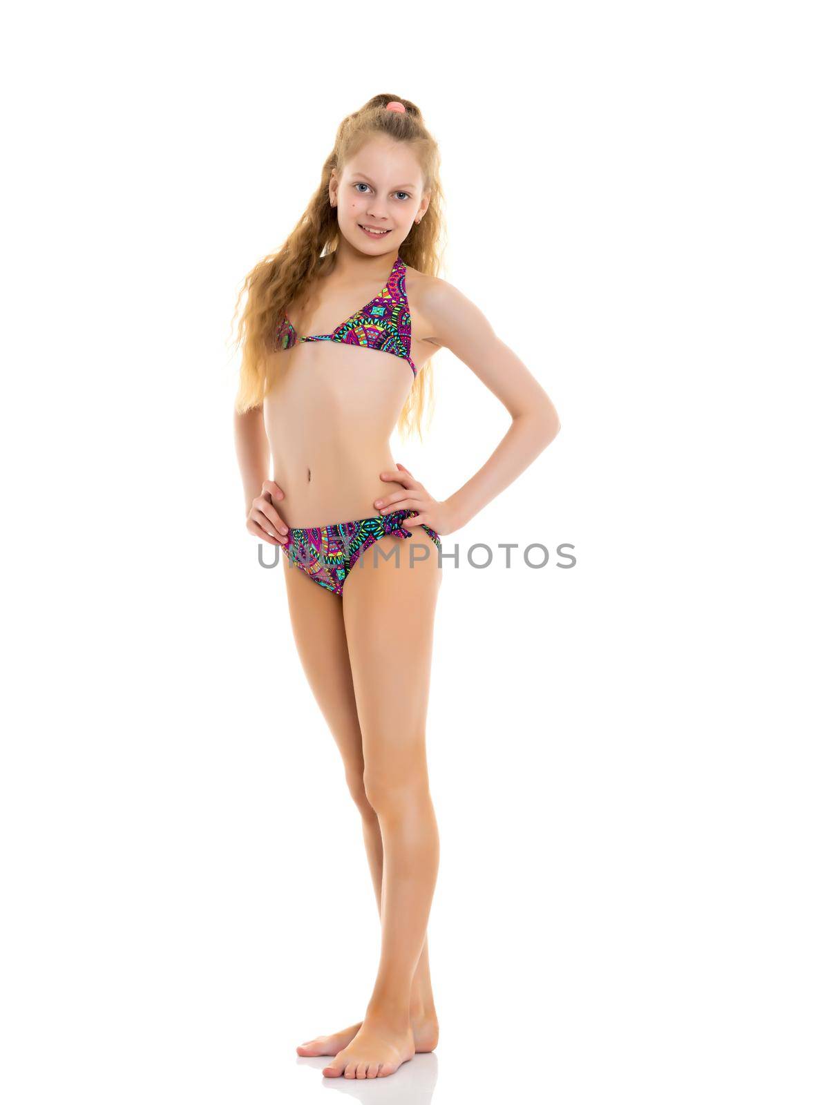 Beautiful little girl schoolgirl in swimsuit in full growth. The concept of a family summer vacation in the sea, sunbathing on the beach. Isolated on white background.