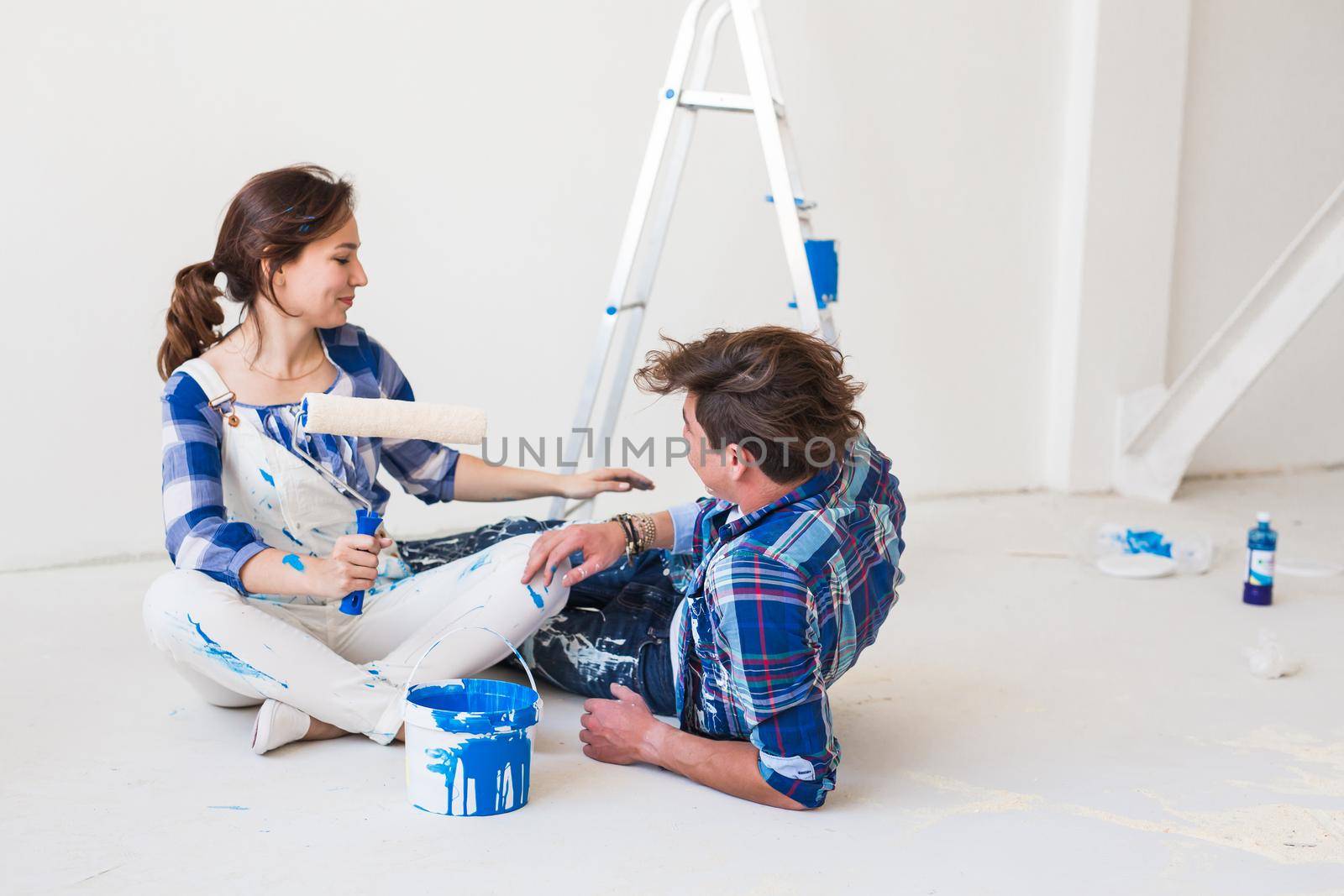 Renovation, redecoration and people concept - young couple doing a renovation in new home.