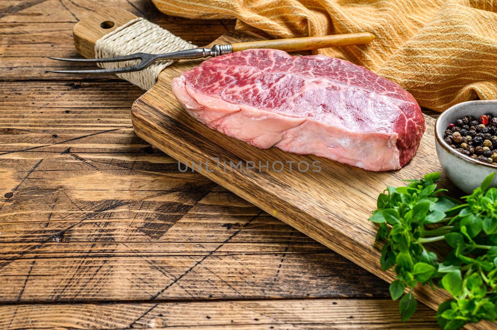 Raw Top Blade beef meat steak. wooden background. Top view. Copy space by Composter