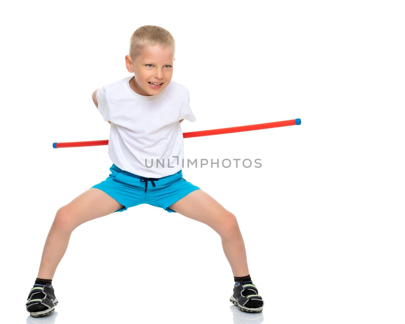 A cute little boy in a clean white T-shirt shows the exercises that he does when practicing fitness. The concept of advertising sports goods, it is possible to inscribe on a white T-shirt. Isolated on white background.