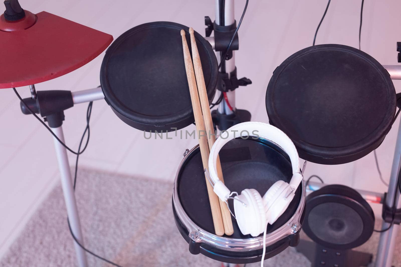 Music, hobby, musical instruments concept - drum with drumsticks and headphones, top view.