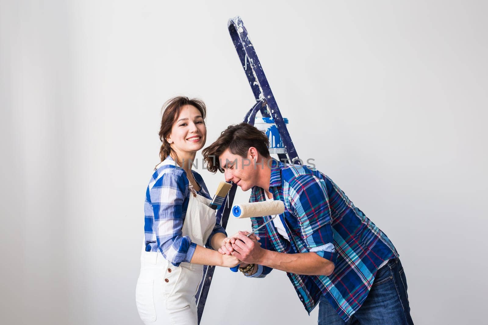 Teamwork, renovation and repair concept - Portrait of funny couple doing redecoration in apartment.