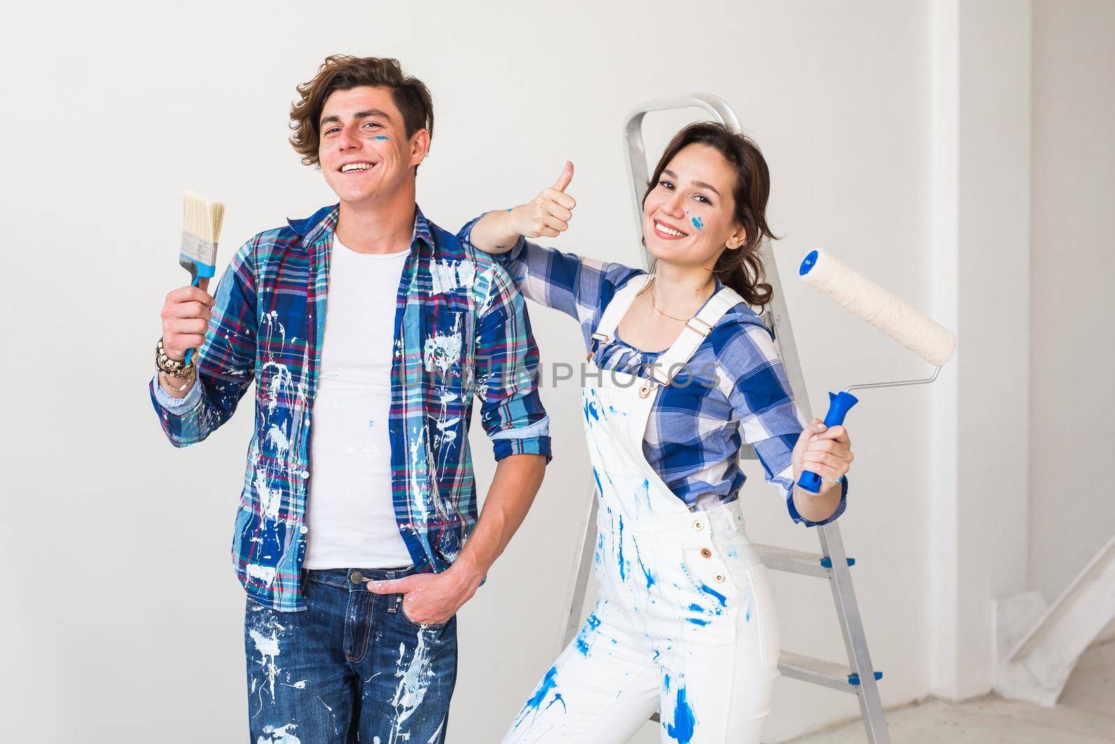 People, repair and apartment concept - Lovely young couple doing renovation in apartment by Satura86