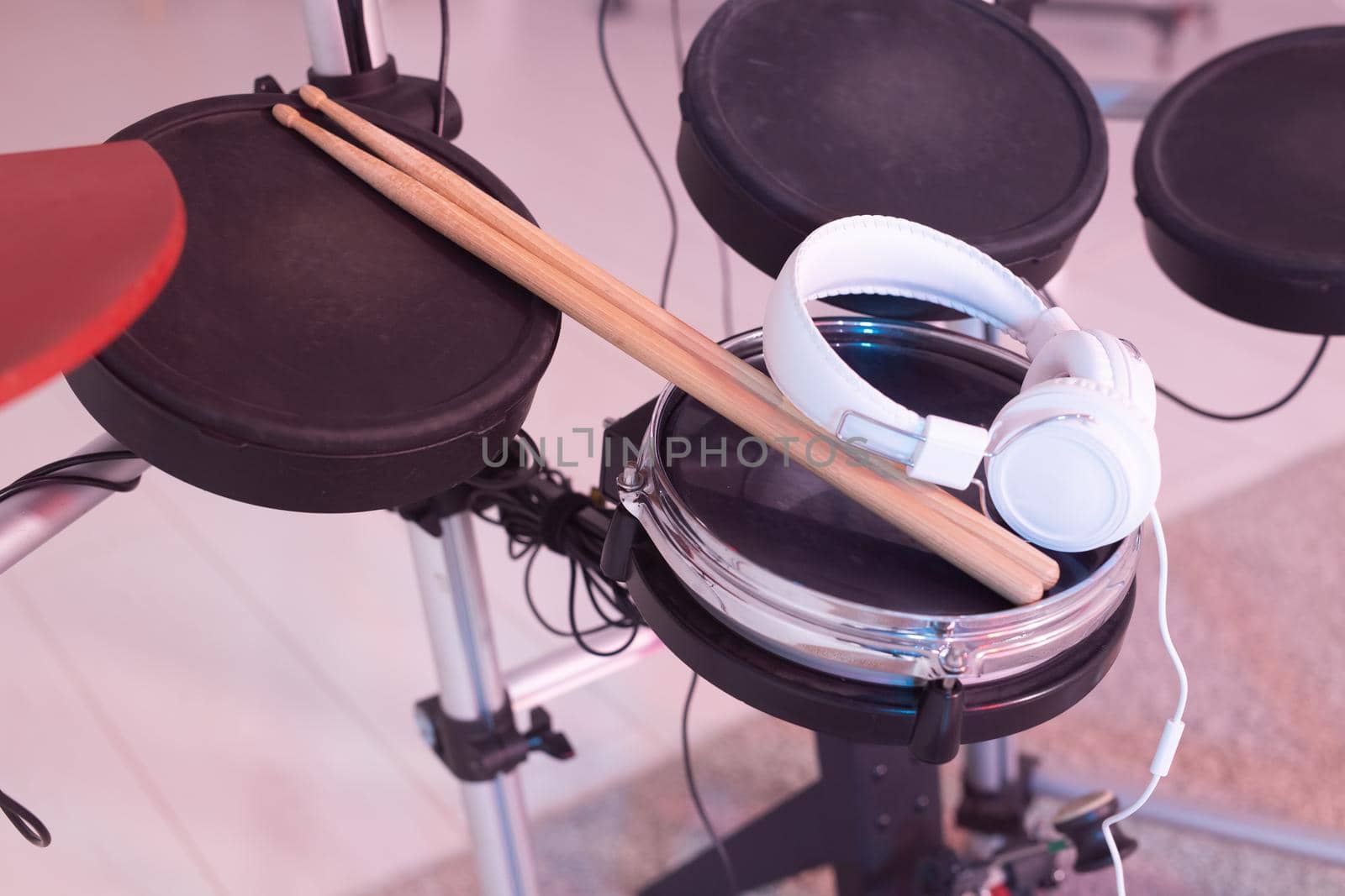 Musical instruments, hobby and music concept - headphone, drumsticks on drum.