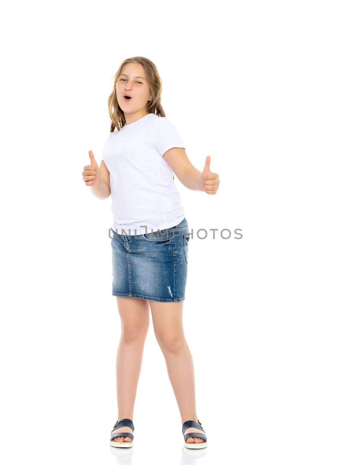 A little school girl in a white empty T-shirt. The concept of advertising and design of T-shirts. Isolated on white background.