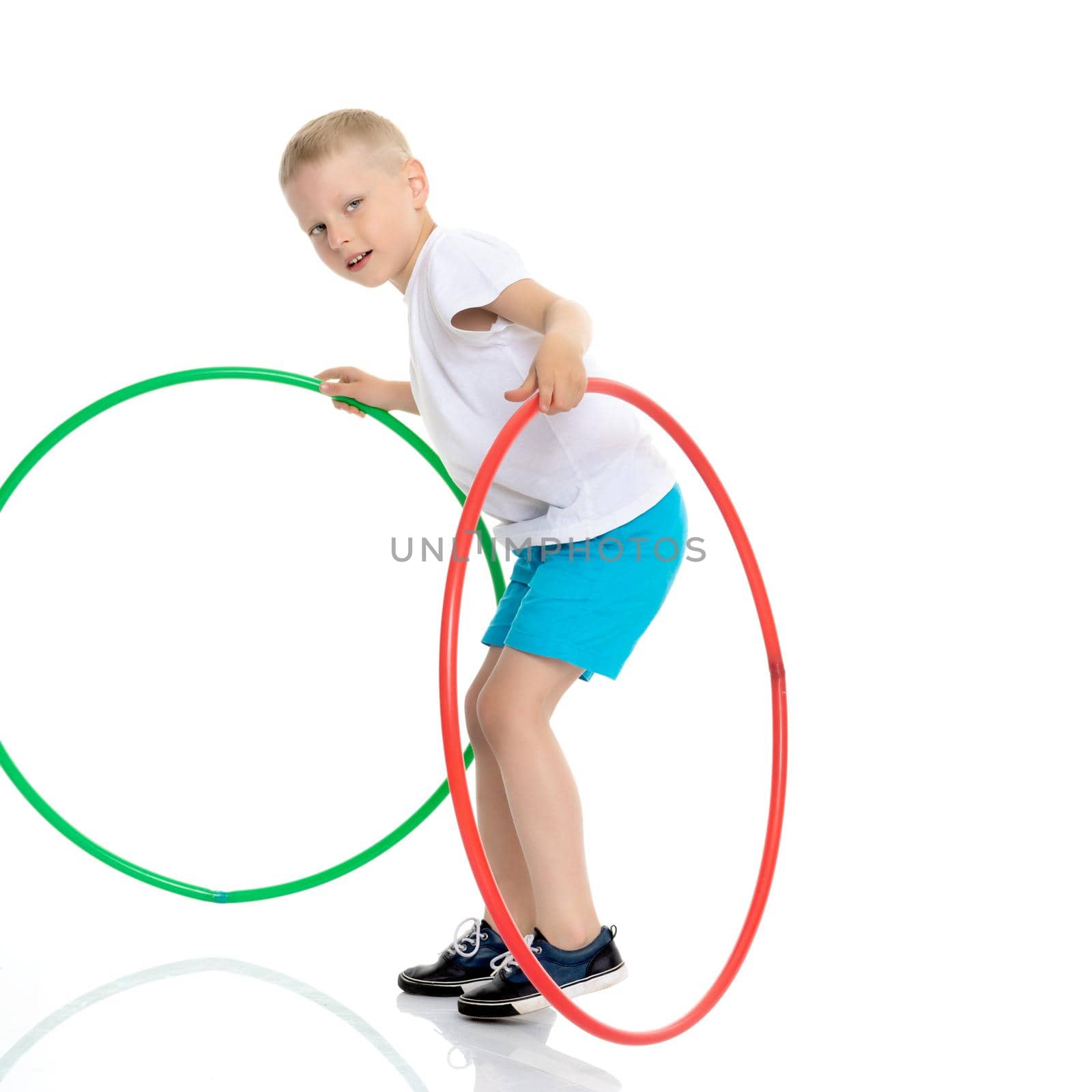 Cute little boy playing with a hoop. Concepts of fitness, children's sports. Isolated on white background.