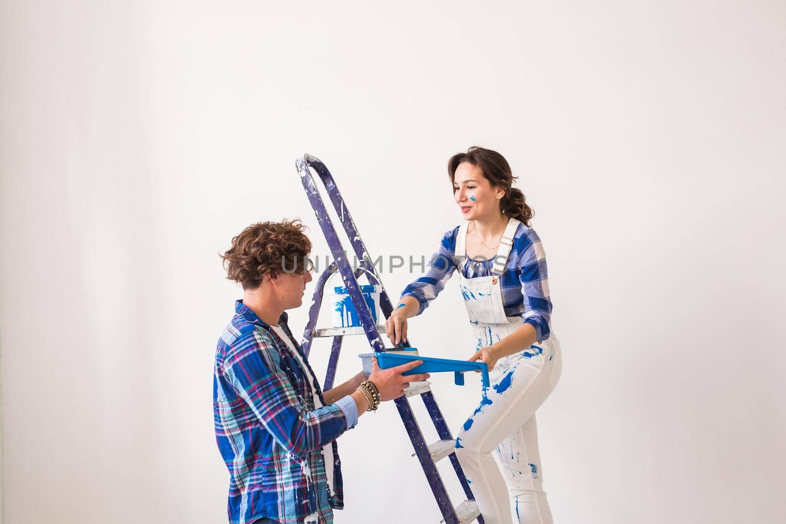 Teamwork, renovation and repair concept - Portrait of funny couple doing redecoration in apartment.