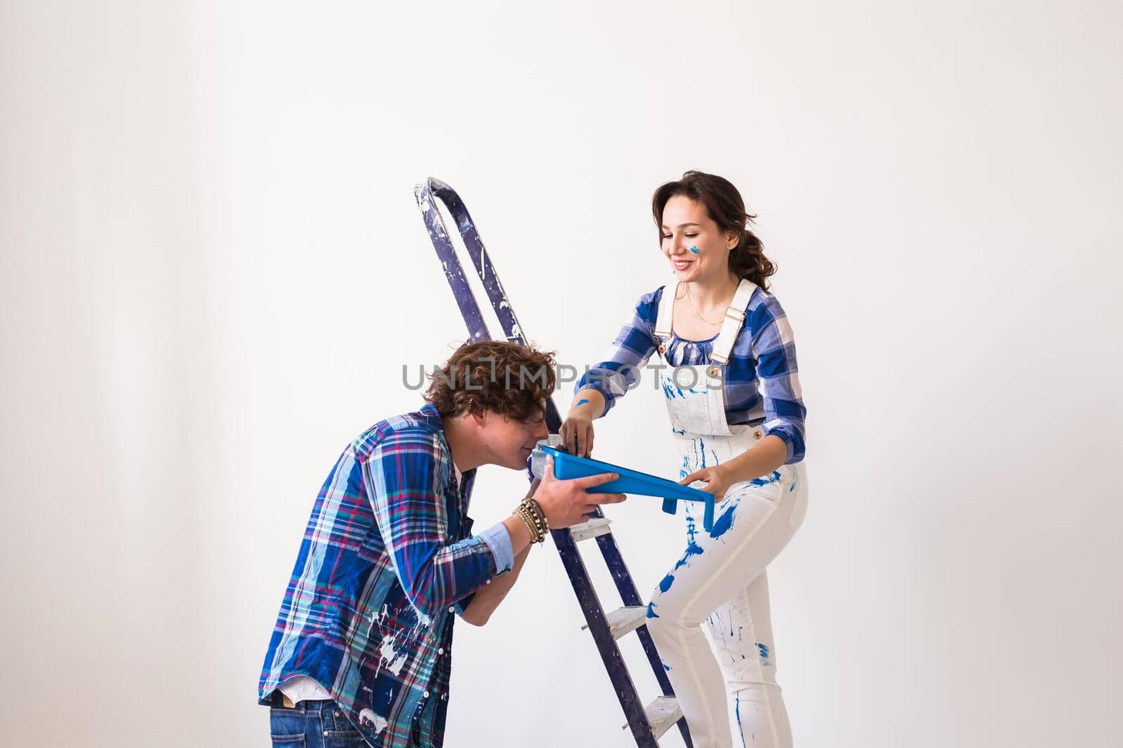 Teamwork, renovation and repair concept - Portrait of funny couple doing redecoration in apartment.