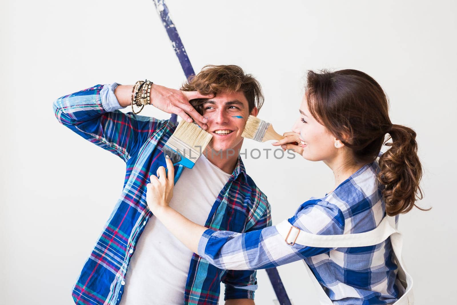 Teamwork, renovation and repair concept - Portrait of funny couple doing redecoration in apartment.