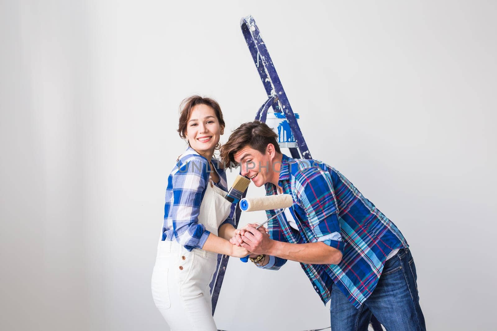 Teamwork, renovation and repair concept - Portrait of funny couple doing redecoration in apartment by Satura86