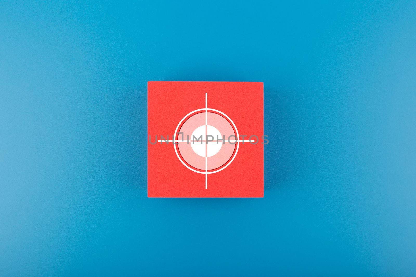 Goal or target symbol on red cube in the middle of blue background. Concept of scoring and setting personal or business goal by Senorina_Irina