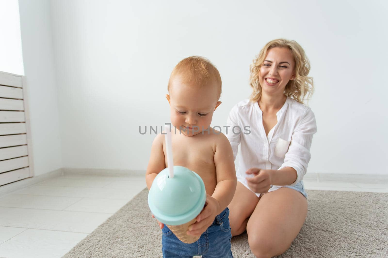 Family and childhood concept - Portrait of mother and baby playing and smiling at home