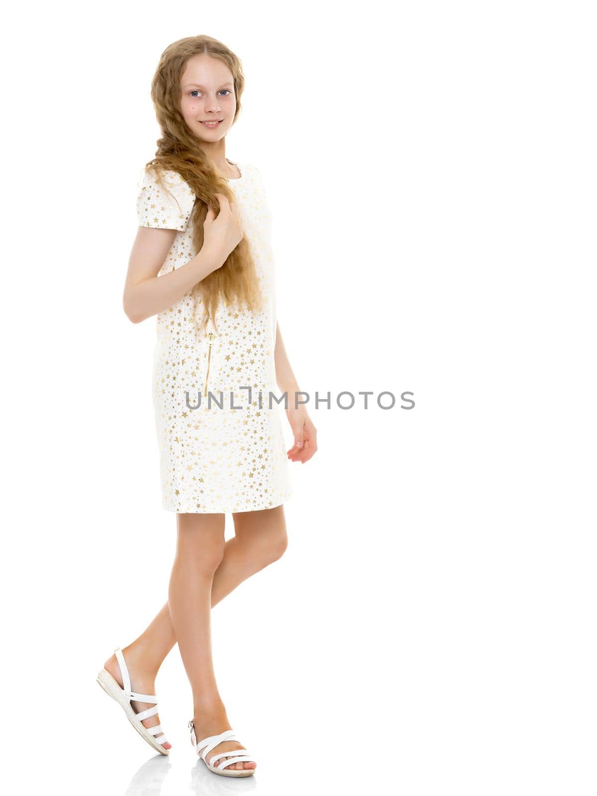 Beautiful little school girl with long silky hair. Studio portrait in full growth. Concept of style and fashion, happy people. Isolated on white background.