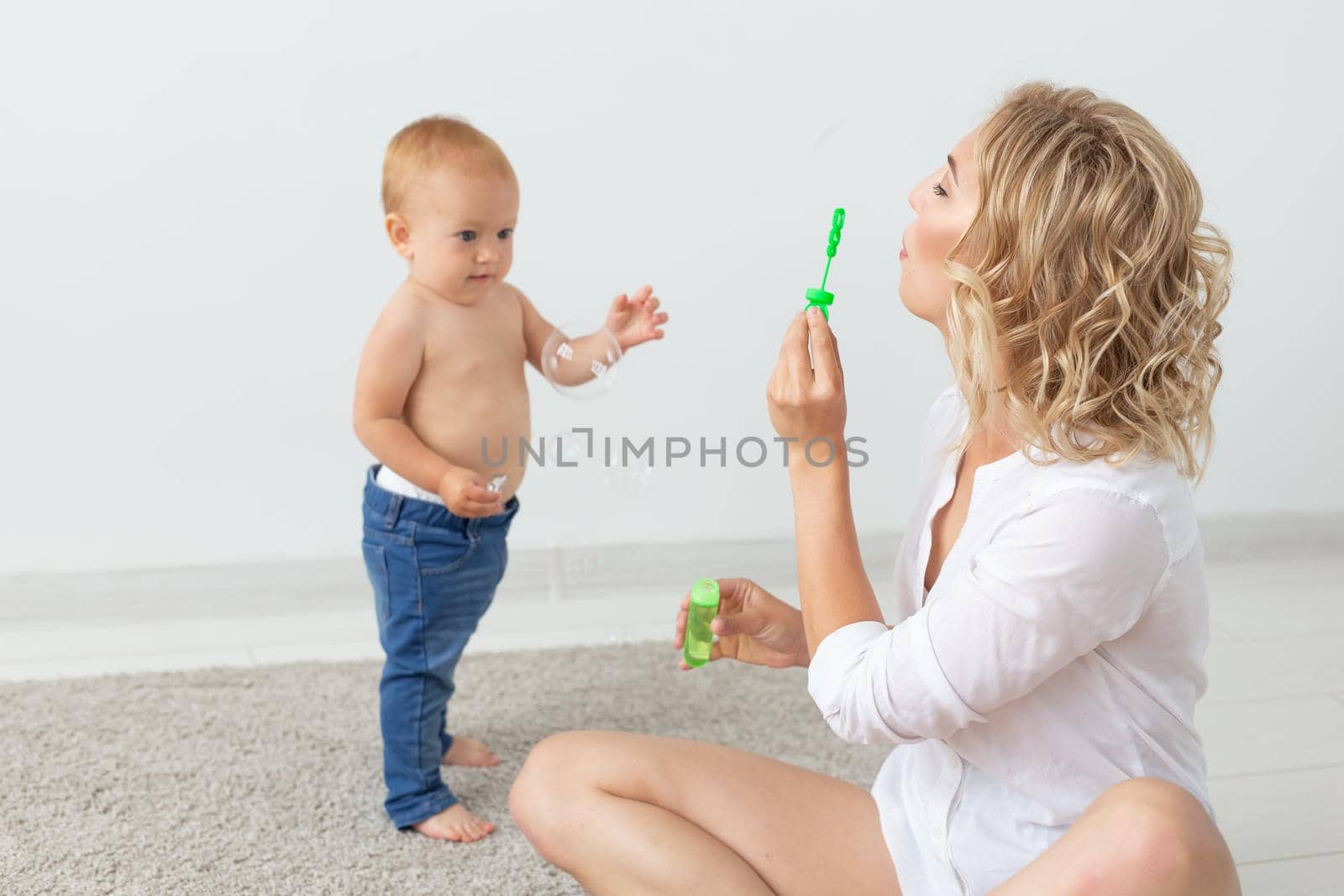 Family and childhood concept - Portrait of mother and baby playing and smiling at home