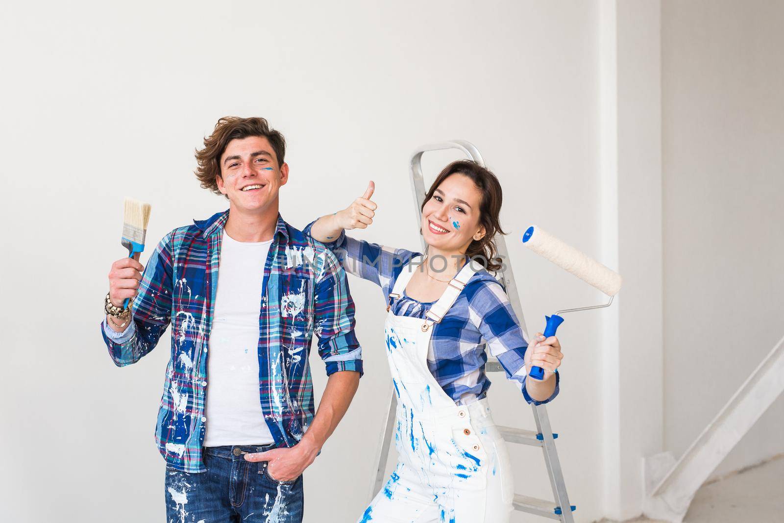 People, repair and apartment concept - Lovely young couple doing renovation in apartment.