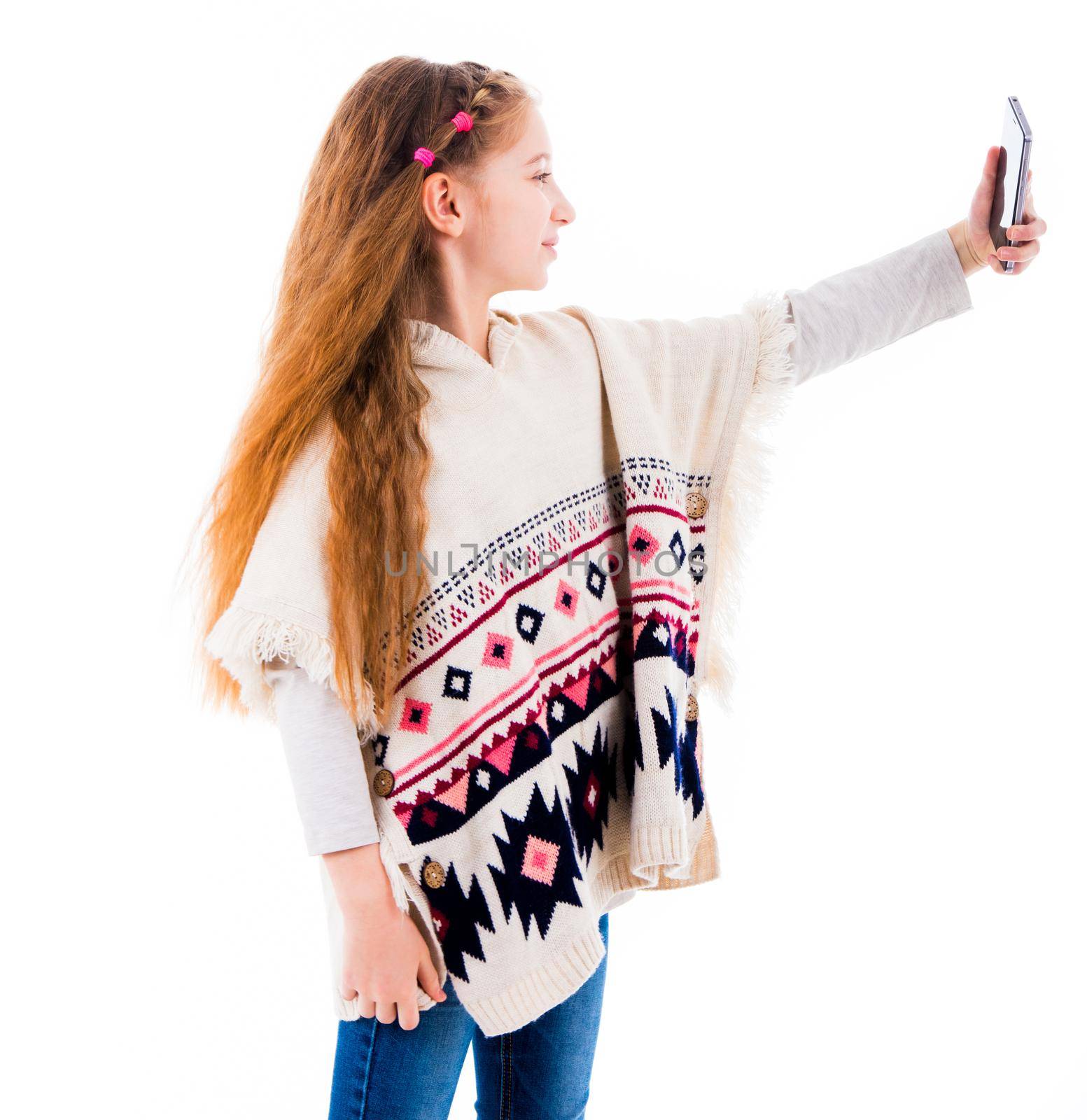 Teenage girl with long hair in poncho making a selfie isolated on white background. Girl taking pictures of herself using smartphone